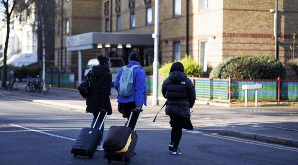 Asylum seekers arriving at a hotel used to accommodate migrants in the UK